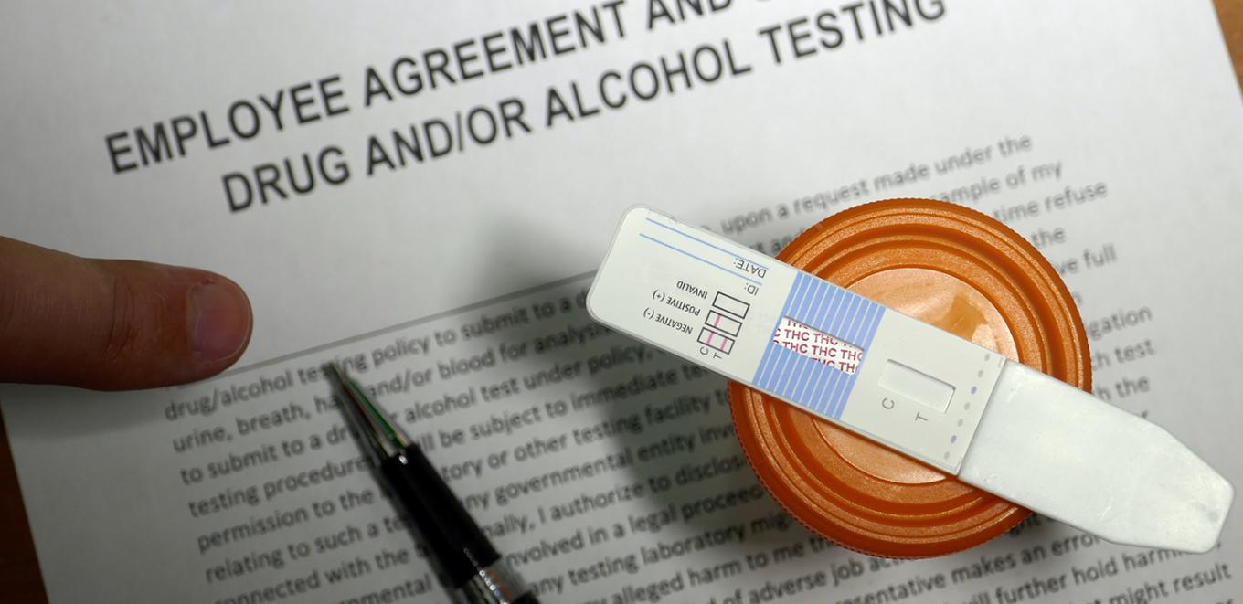 overhead view of a pen on top of an employee agreement for drug and alcohol testing