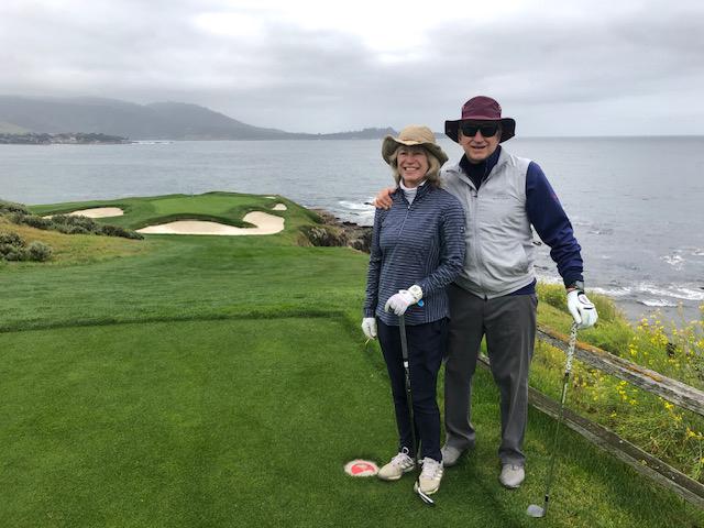 Scott and Heidi Smith on a golf course next to water.