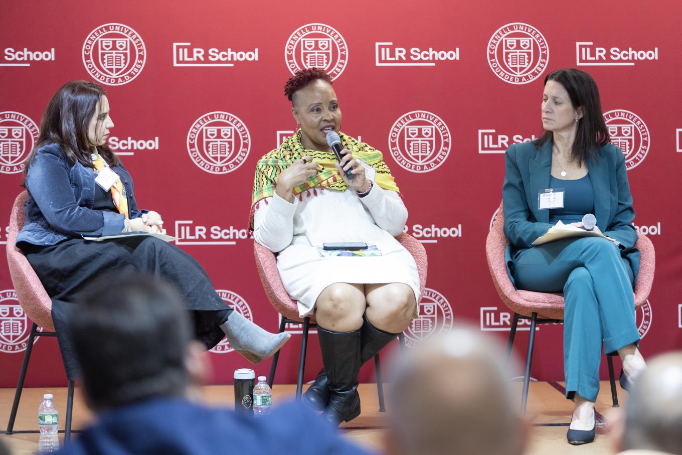Allison Julien sitting between two women speaking to ULI grad group