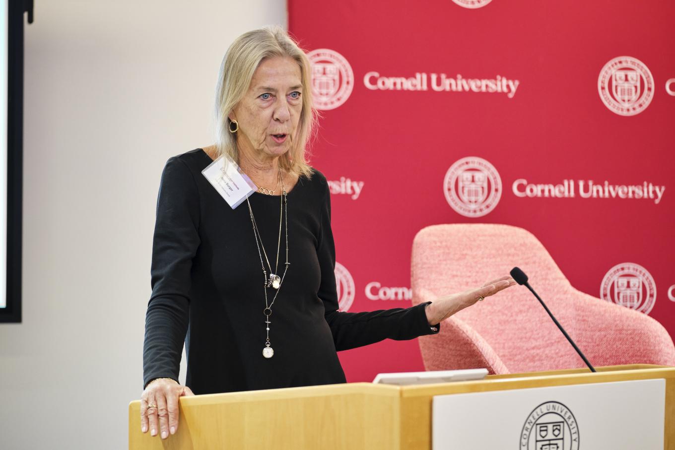 Anna Burger presents at the 2025 GLI Conference in New York City, standing at a podium in front of a red backdrop that says 'Cornell University'