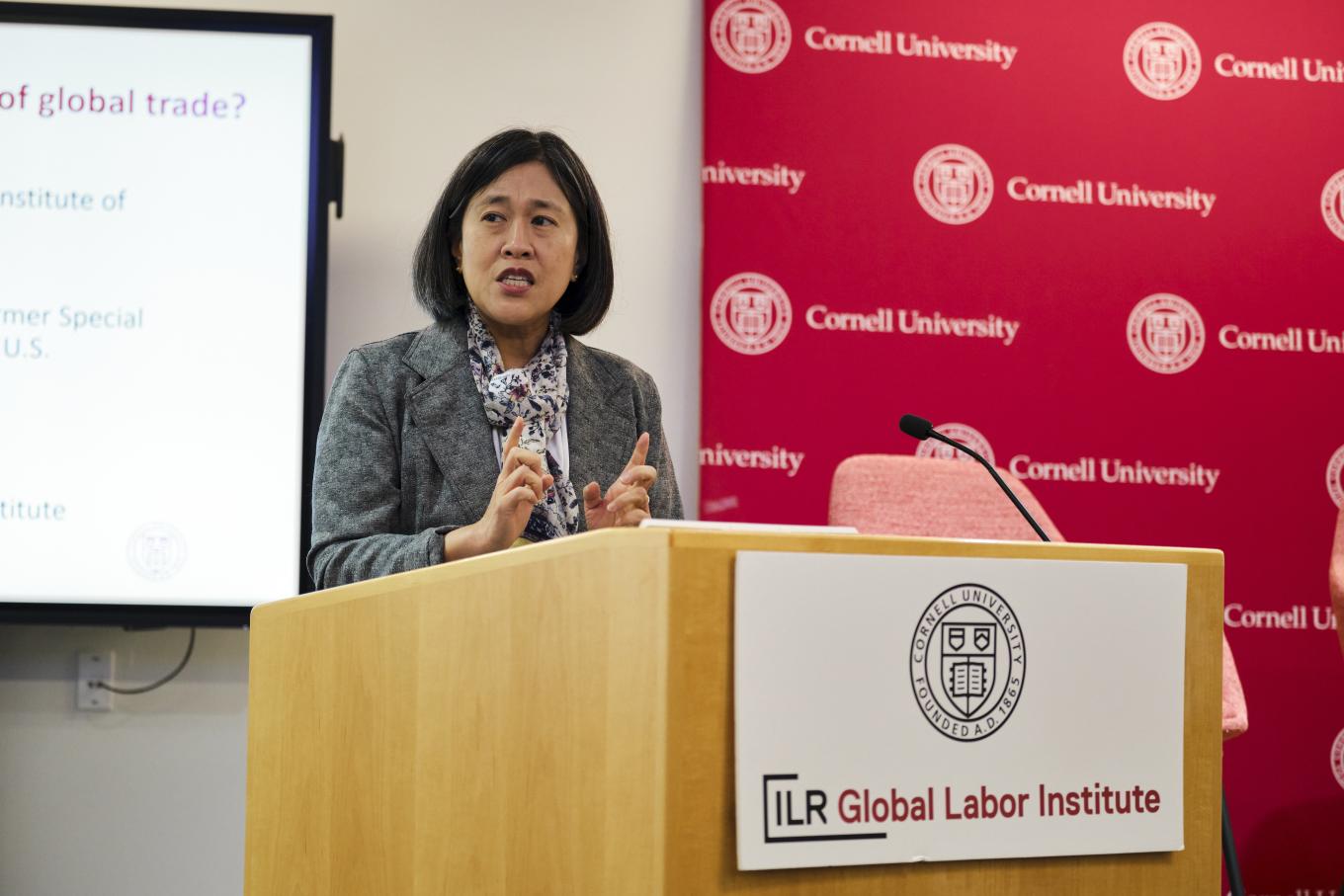Ambassador Katherine Tai stands at a podium at the 2025 Global Labor Institute conference in New York City, with a red backdrop reading Cornell University