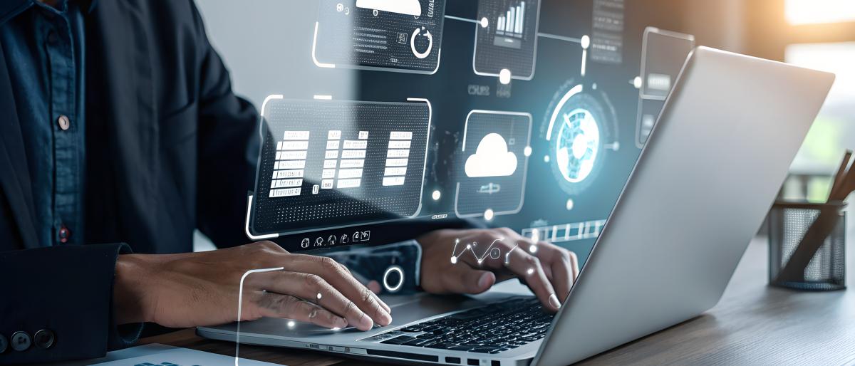 Professional working on a laptop with digital dashboards and data visualizations, representing data-driven decision making and enterprise performance.