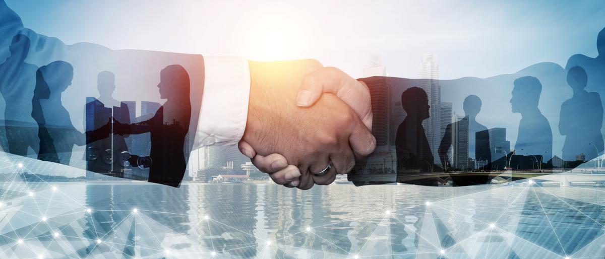 Two business professionals shaking hands in the foreground, overlaid with silhouettes of people networking and a modern city skyline, symbolizing partnership, collaboration, and professional relationships.