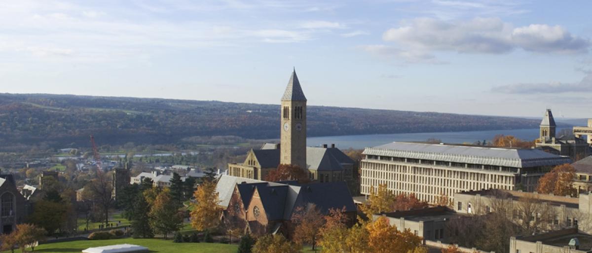 Clock tower on campus with Cayuga Lake behind it