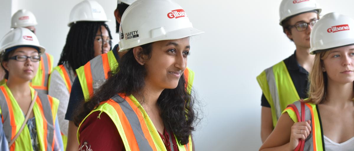 students wear hard hats and high-visability vests