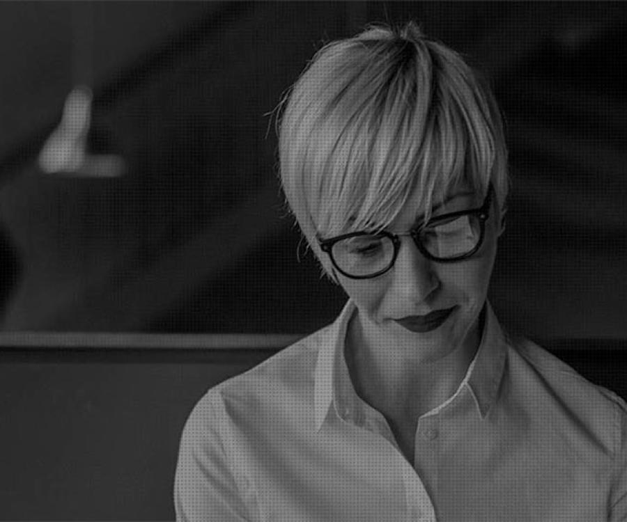 Professional woman sits looking down at her work.