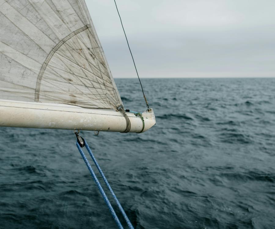 Gently waving sea with sail entering frame at top left corner