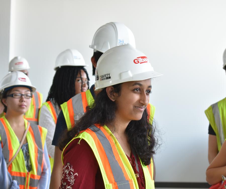 students wear hard hats and high-visability vests