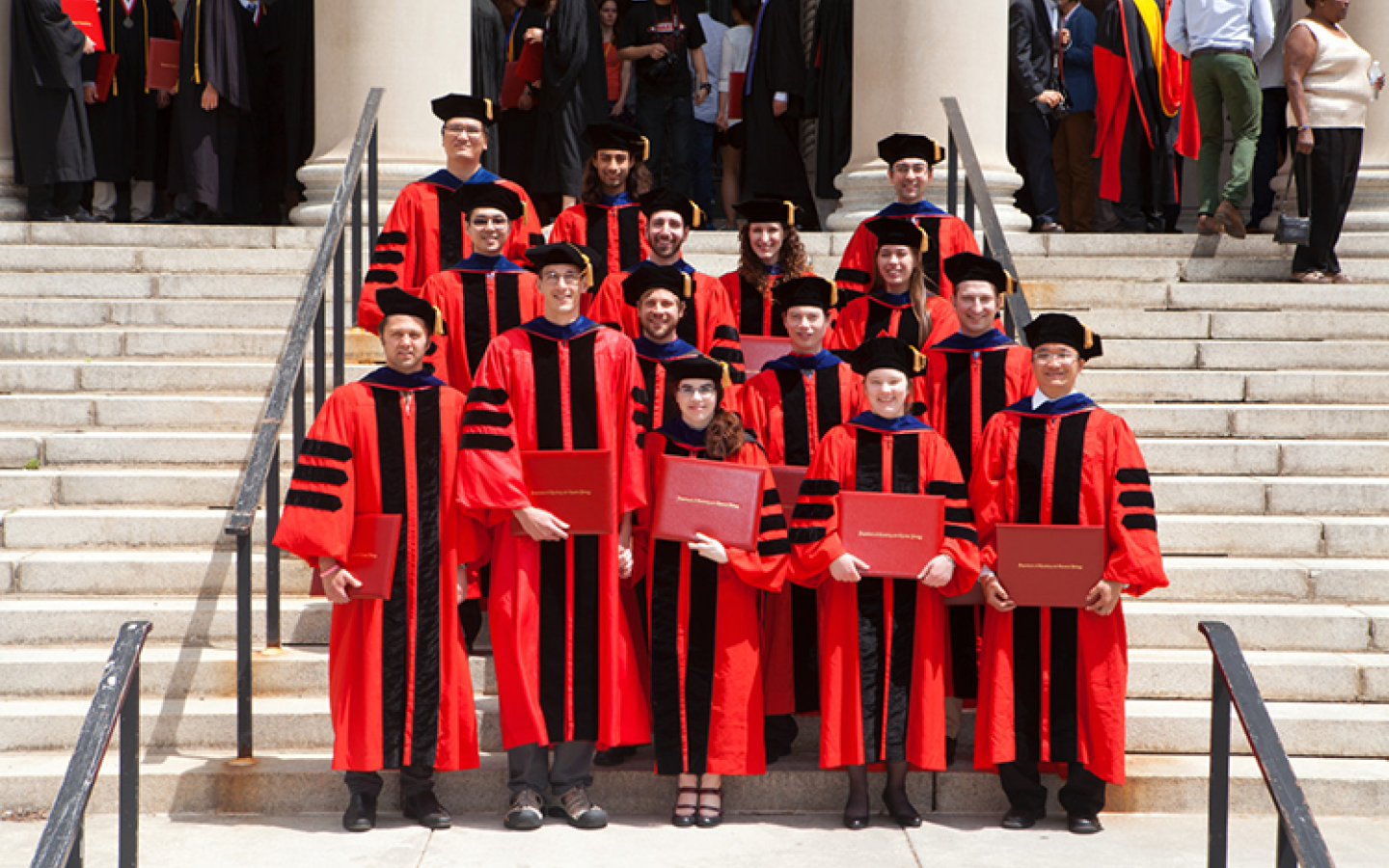 PhD students wearing red robes at Commencement
