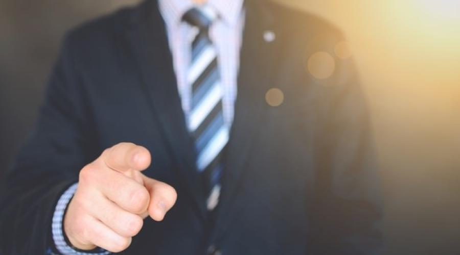 Man in suit pointing a finger toward the viewer