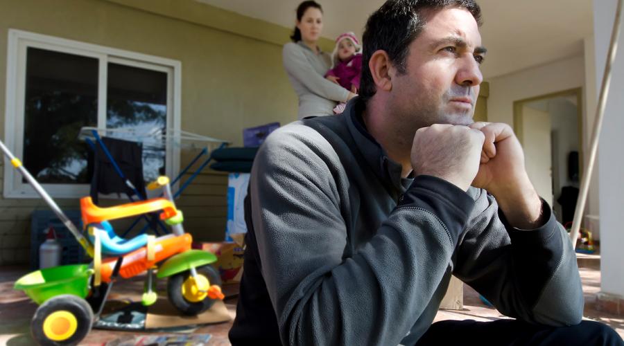 Frustrated man at home with family in the background