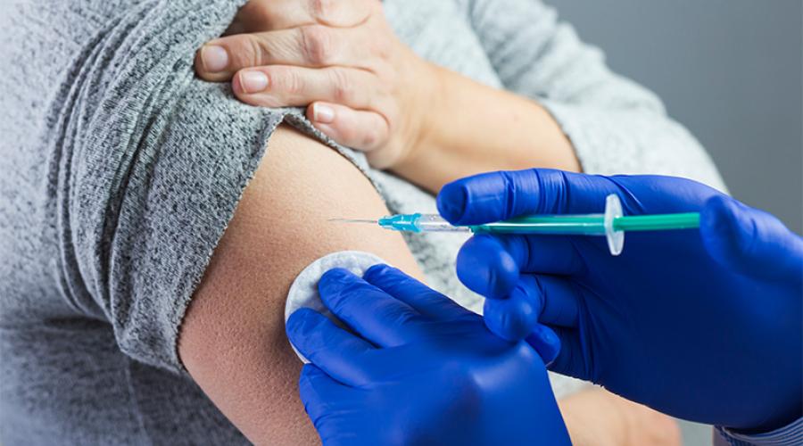 woman receiving a vaccination shot in the upper arm