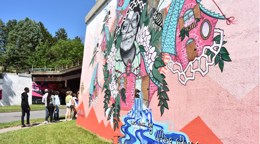 mural with the words we rise by lifting others. 