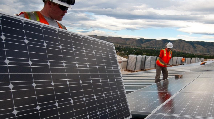 Workers install solar panels