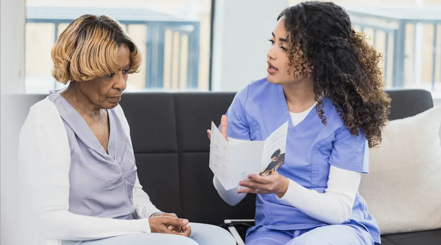 Nurse and patient converse in hospital setting