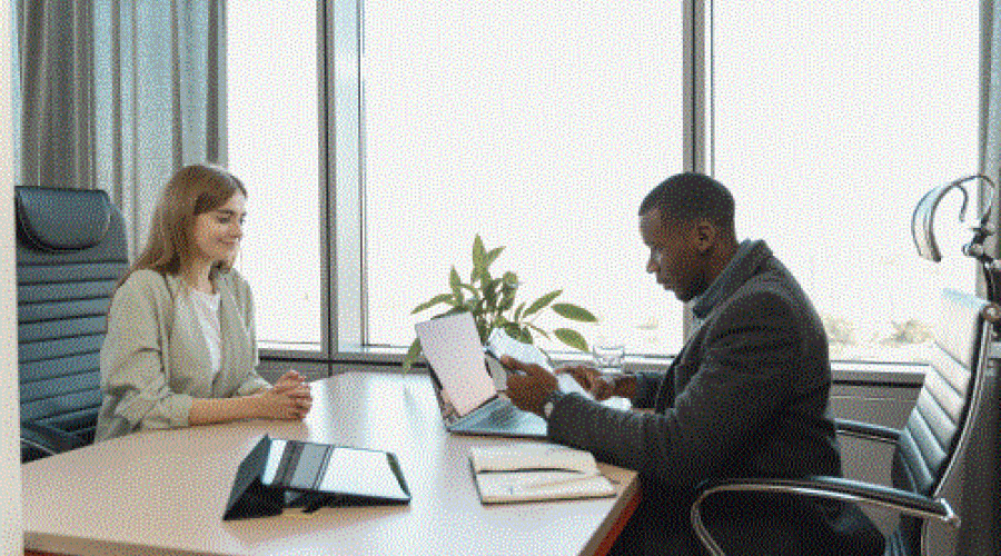 two people talking on either side of a desk