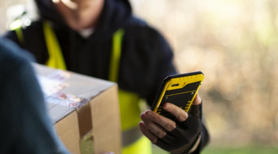 Delivery person using a cell phone to complete a delivery