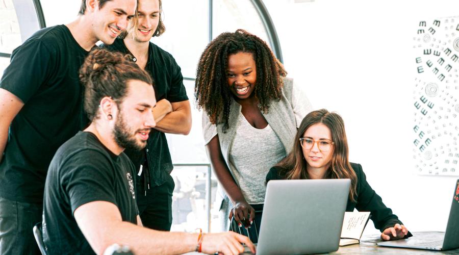 workers around a laptop 