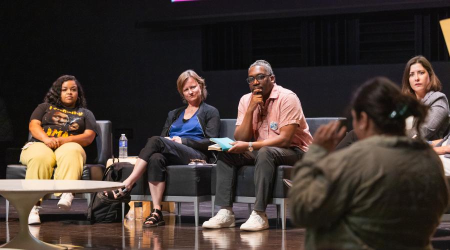 panelists listen to audience member asking question