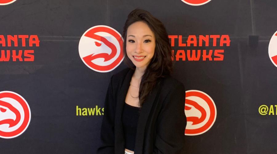Jennifer Choi ’08 standing in front of an Atlanta Hawks step and repeat. 