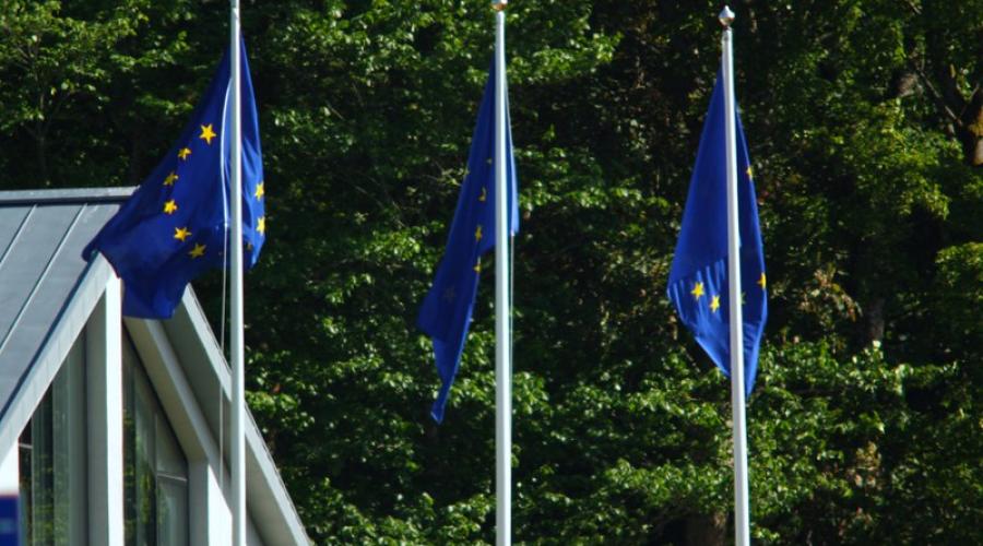Three European Union flags fly from flagpoles
