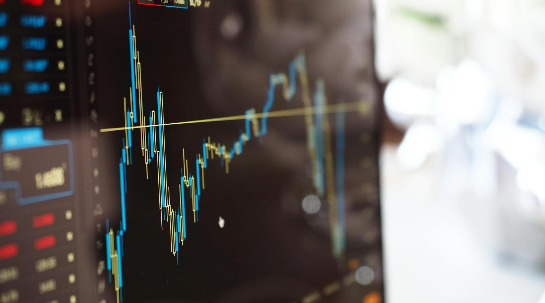 close up image of a monitor displaying line graph rising and falling