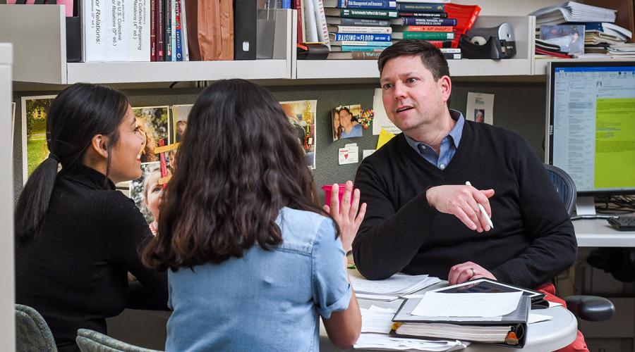 Adam Seth Litwin speaks with two undergraduates in his office in Ives Hall. 