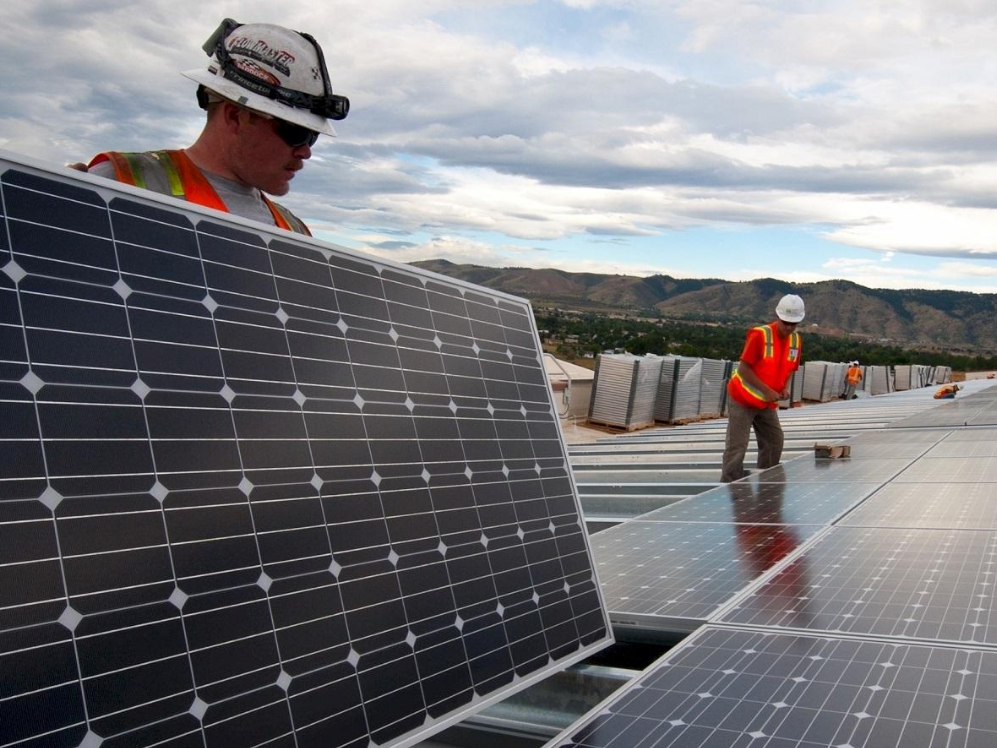Workers install solar panels