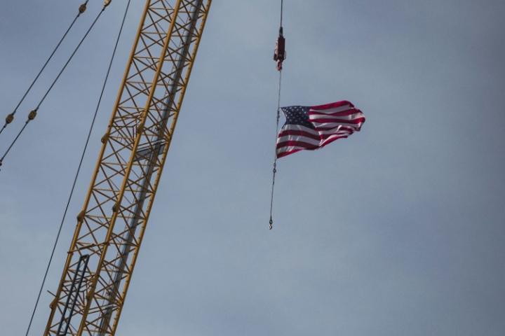 US flag coming down a crane