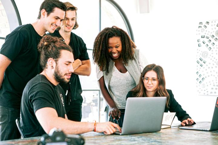 workers around a laptop 