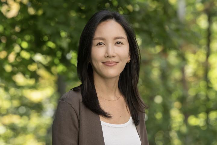 Image of a smiling woman with trees in the background