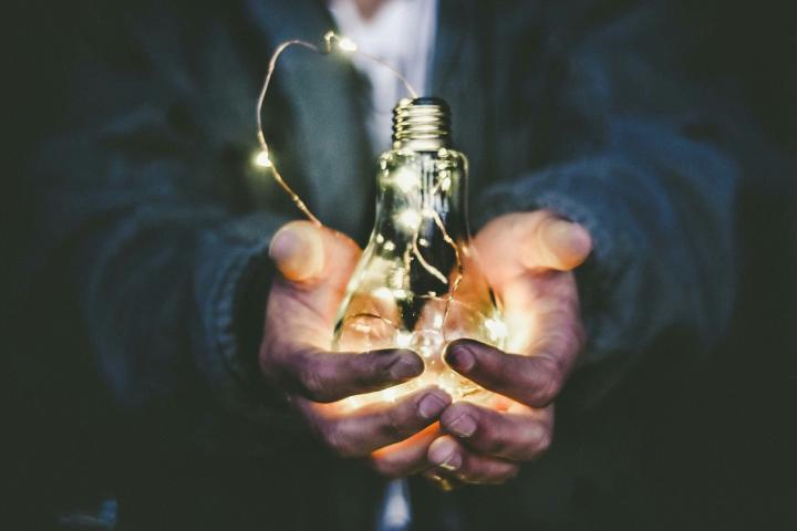 hands holding a lightbulb