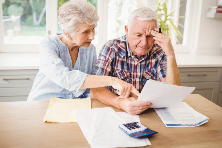 An elderly couple go over their finances. 