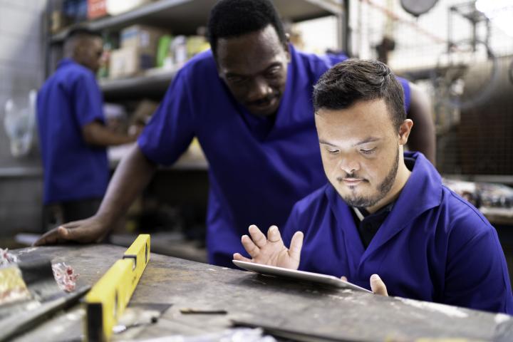 Colleagues using digital tablet and working in industry
