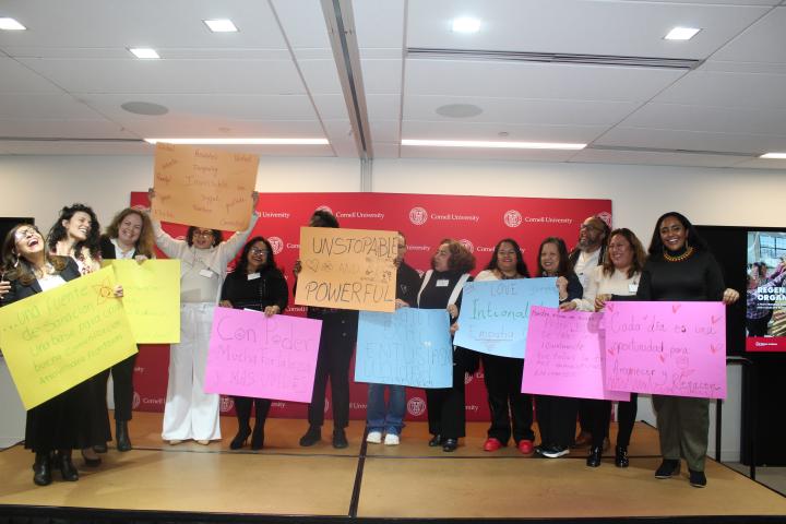 Group of people on stage holding up signs