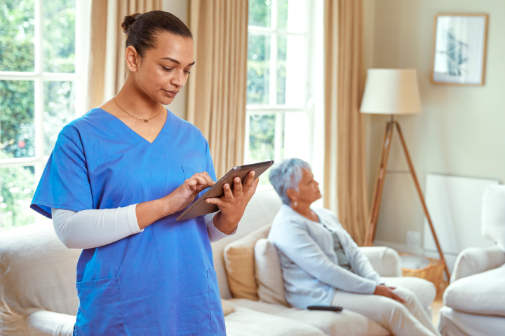 A home healthcare nurse stands with her iPad. 
