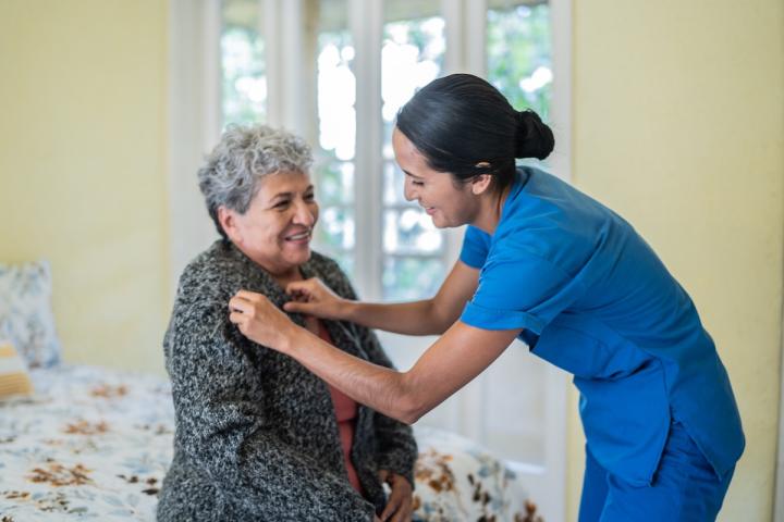 caregiver assisting in a bedroom