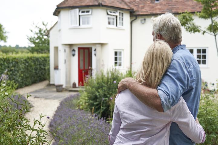 A mature couple stares at their family home