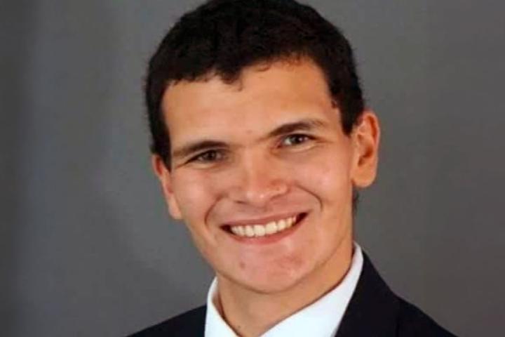 James Gill smiling while wearing a suit